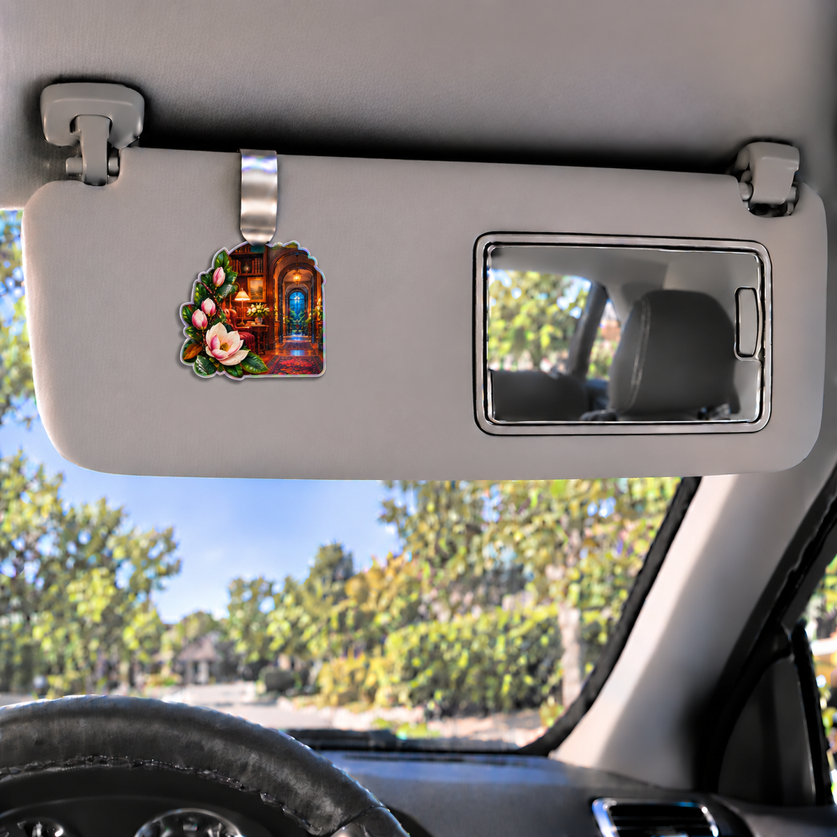 Magnolia Quiet Corner Holographic Car Visor Clip with printed optical 3D artwork in its use setting